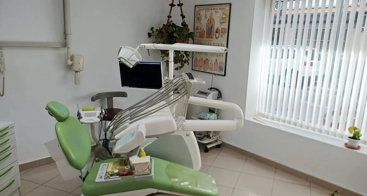 Sala de tratamiento con sillón clínico, monitor y póster anatómico